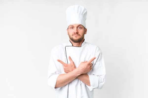 Jonge Kaukasische Chef Kok Geïsoleerde Witte Achtergrond Wijzend Naar Lateralen — Stockfoto