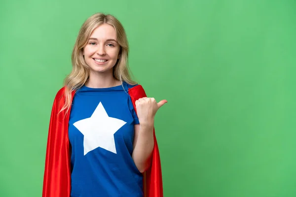 Super Hero English woman over isolated background pointing to the side to present a product