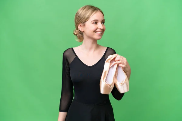 Young English woman practicing ballet over isolated background looking side