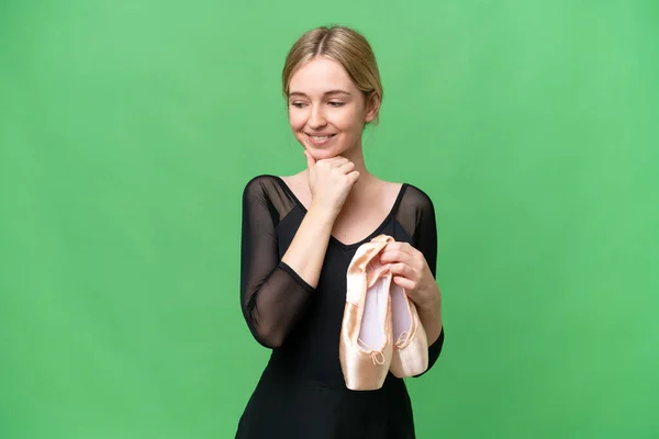 Young English woman practicing ballet over isolated background looking to the side and smiling