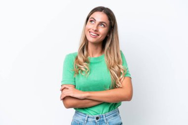 Genç Uruguaylı kadın beyaz arka planda izole edilmiş gülümserken yukarı bakıyor