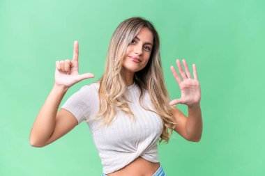 Genç Uruguaylı kadın tecrit edilmiş arka planda yediyi parmaklarıyla sayıyor