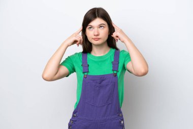 Genç Rus kadın mavi arka planda izole edilmiş. Şüpheleri ve düşünceleri var.