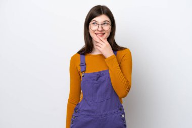 Genç Rus kadın mavi arka planda izole edilmiş gülümserken yukarı bakıyor