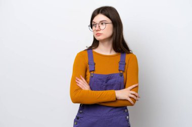 Mavi arka planda izole edilmiş genç Rus kadın kollarını çapraz tutuyor.