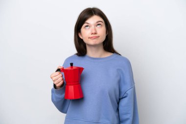 Young Russian woman holding coffee pot isolated on white background and looking up