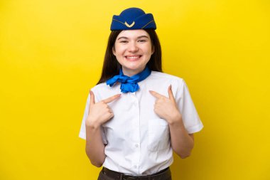 Airplane stewardess Russian woman isolated on yellow background with surprise facial expression