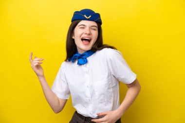 Uçak hostesi Rus kadın, sarı arka planda izole edilmiş gitar hareketi yapıyor.