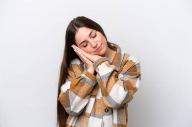 Young girl isolated on white background making sleep gesture in dorable expression