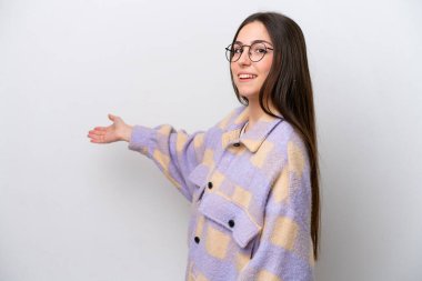 Young girl isolated on white background extending hands to the side for inviting to come