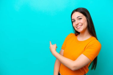 Kafkasyalı genç bir kadın mavi arka planda izole edilmiş.