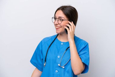 surgeon doctor woman holding tools isolated on white background keeping a conversation with the mobile phone with someone