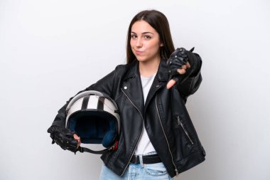 Young girl with a motorcycle helmet isolated on white background showing thumb down with negative expression