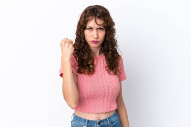 Kıvırcık saçlı genç bir kadın mutsuz bir ifadeyle beyaz arka planda izole edilmiş.