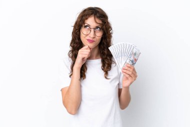 Kıvırcık saçlı, çok para alan genç bir kadın beyaz arka planda izole edilmiş bir geçmişi var.