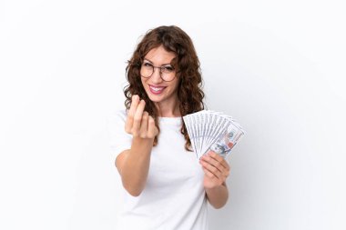 Kıvırcık saçlı, çok para alan genç bir kadın beyaz arka planda izole edilmiş para hareketi yapıyor.