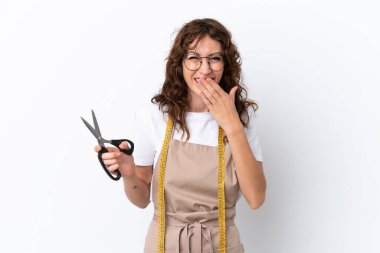 Beyaz arka planda izole edilmiş, mutlu ve gülümseyen, ağzı kapalı beyaz kadın terzi.