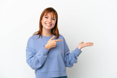 Beyaz arka planda izole edilmiş kızıl saçlı bir kız. Avucunun içinde bir reklam koymak için görsel alan tutuyor.