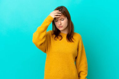 Kızıl saçlı kız mavi arka planda baş ağrısı ile izole edilmiş.