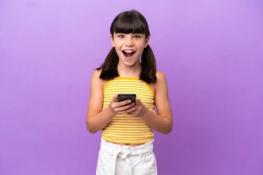 Mor arka planda izole edilmiş küçük beyaz çocuk şaşırdı ve bir mesaj gönderiyor.