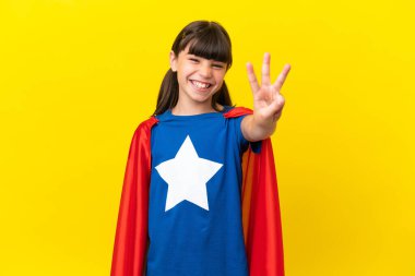 Mor arka planda izole edilmiş küçük süper kahraman çocuk mutlu ve parmaklarıyla üçe kadar sayıyor.