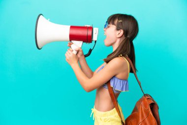 Mavi arka planda izole bir şekilde plaja giden beyaz bir çocuk megafonla bağırıyor.