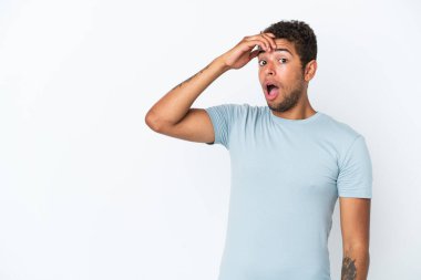 Beyaz arka planda izole edilmiş yakışıklı Brezilyalı bir adam. Yan tarafa bakarken sürpriz jest yapıyor.