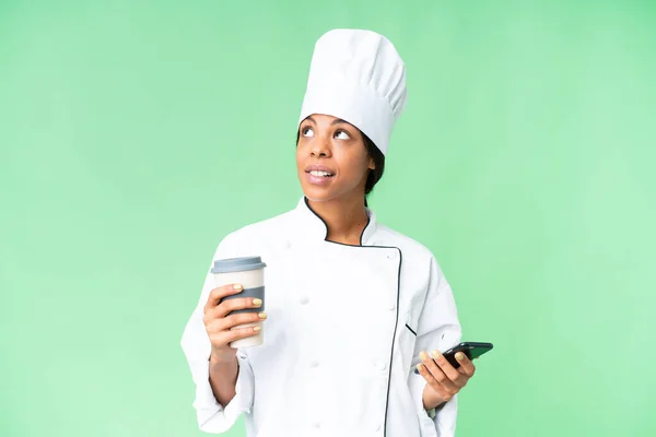 아프리카 미국인 요리사가 커피를 전화를 무언가를 생각하면서 — 스톡 사진