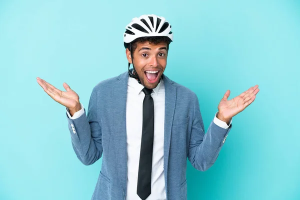 Young business Brazilian man with bike helmet isolated on blue background with shocked facial expression