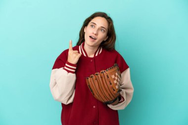 Beyzbol oynayan beyaz bir kadın mavi arka planda izole edilmiş bir şekilde parmak kaldırmayı düşünüyor.