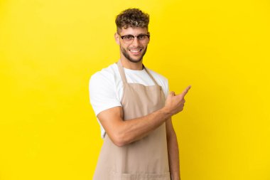 Restoran garsonu sarışın adam sarı arka planda izole edilmiş.