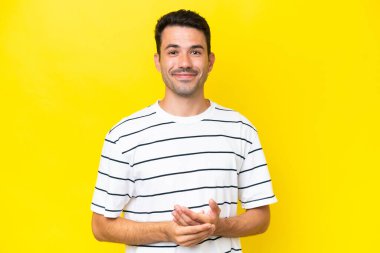 Genç yakışıklı adam, izole edilmiş sarı arka plan gülüyor.