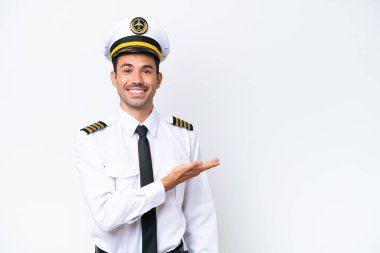 İzole edilmiş beyaz arka plan üzerinde uçak pilotu gülümserken bir fikir sunuyor.