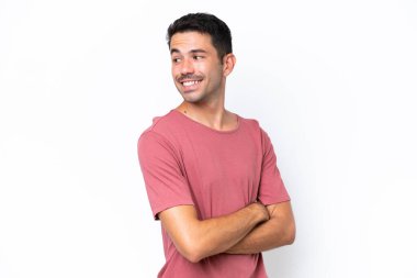 Genç yakışıklı adam soyutlanmış beyaz arka planda yan tarafa bakıyor ve gülümsüyor