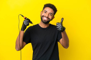 Dövme sanatçısı Brezilyalı adam sarı arka planda iyi bir şey olduğu için izole edilmiş.