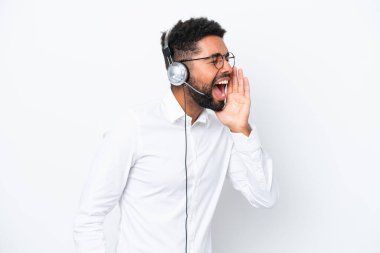 Tele pazarlamacı Brezilyalı bir adam beyaz arka planda izole edilmiş bir kulaklıkla çalışıyor ve ağzı sonuna kadar açık bağırıyor.