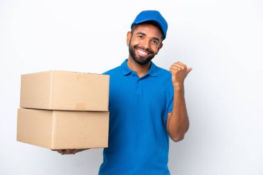 Teslimat yapan Brezilyalı beyaz arka planda izole edilmiş bir adam bir ürün sunmak için kenarı işaret ediyor
