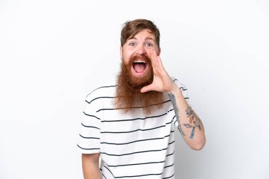 Beyaz arka planda sakallı kızıl saçlı adam ağzı açık bağırıyor.