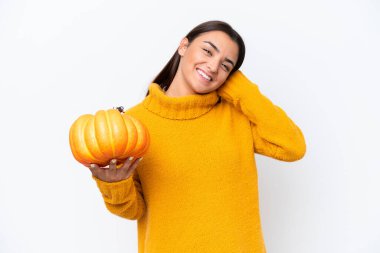 Beyaz arka planda izole edilmiş balkabağı tutan beyaz bir kadın gülüyor.