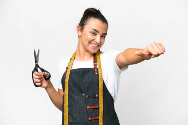 Terzi kadın, izole edilmiş beyaz arka planda baş parmak hareketi yapıyor.