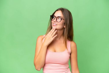 Genç, güzel bir kadın, soyutlanmış arka planda gülümserken yukarı bakıyor