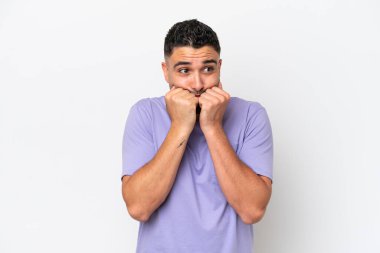 Beyaz arka planda izole edilmiş genç Arap yakışıklı adam gergin ve korkmuş, elleriyle suni teneffüs yapıyor.