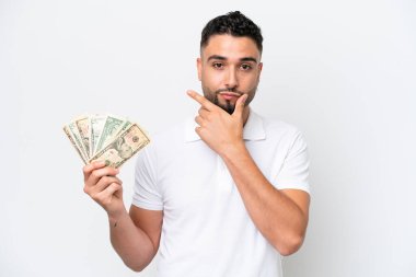 Genç bir Arap, beyaz arka planda izole edilmiş bir şekilde çok para alıyor.