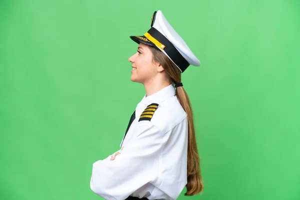 Airplane pilot woman over isolated chroma key background in lateral position
