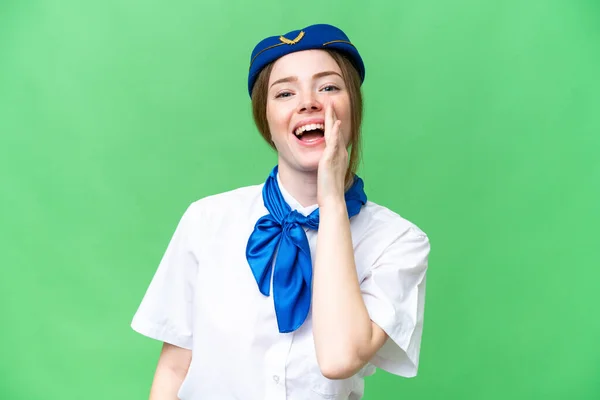 Airplane stewardess over isolated chroma key background shouting with mouth wide open