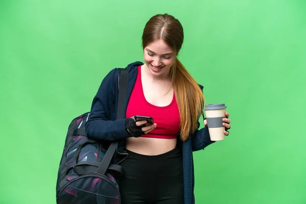 Young sport woman with sport bag over isolated chroma key background holding coffee to take away and a mobile
