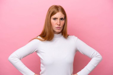 Genç kızıl saçlı kadın pembe arka planda izole edilmiş kızgın.