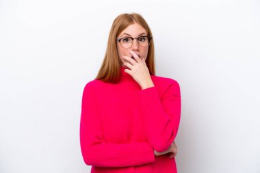 Beyaz arka planda izole edilmiş genç, kızıl saçlı kadın sağa bakarken şaşırmış ve şok olmuştu.