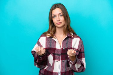 Kafkasyalı genç bir kadın mavi arka planda izole edilmiş para hareketi yapıyor ama mahvolmuş.