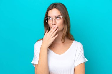 Mavi arka planda soyutlanmış, gözlüklü ve şüpheleri olan beyaz bir kadın.